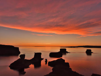 Scenic view of sea against romantic sky at sunset