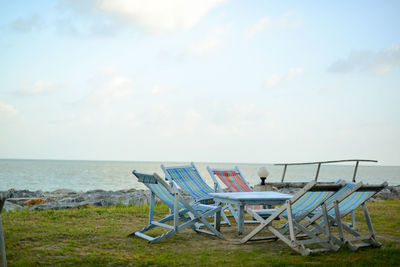 Chairs on beach against sky