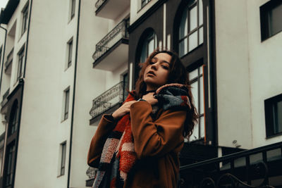 Low angle view of woman standing against building