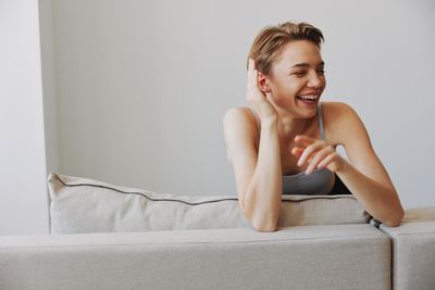 Young woman sitting on sofa at home