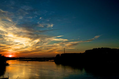 Scenic view of river against sky at sunset