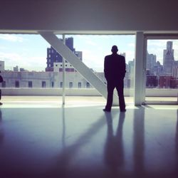 Full length of silhouette man standing in city against sky