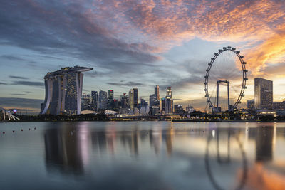 Reflection of buildings in city at sunset