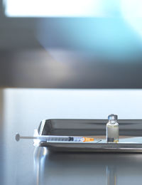 Vaccine vial with syringe in tray on desk