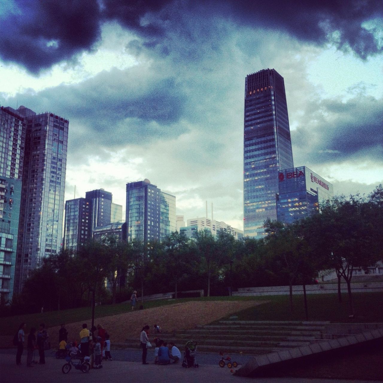 building exterior, city, sky, architecture, built structure, cloud - sky, skyscraper, modern, cloudy, tree, office building, city life, tower, large group of people, urban skyline, cityscape, cloud, tall - high, park - man made space, building