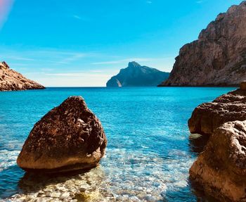 Rock formation in sea against sky