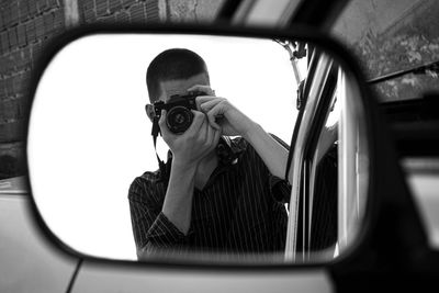 Young man takes a photo with an old camera.