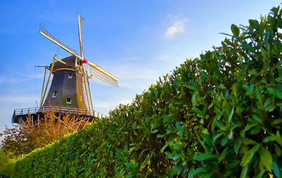 Traditional windmill on landscape against sky