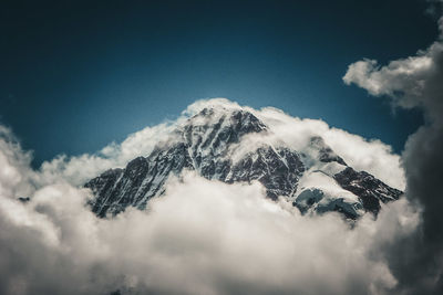 Low angle view of snowcapped mountain against sky
