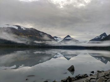 Scenic view of lake by mountains against sky