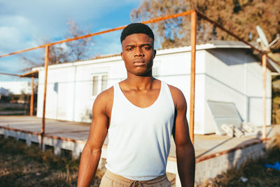 Portrait of young man standing against built structure