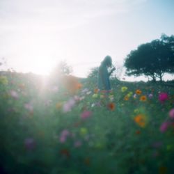 Woman standing on field against sky