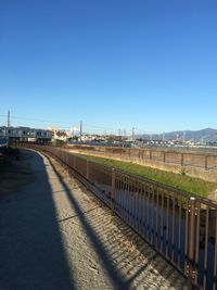 Empty road against clear blue sky