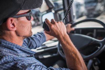 Portrait of man holding mobile phone in car