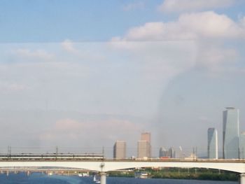 Bridge over cityscape against sky