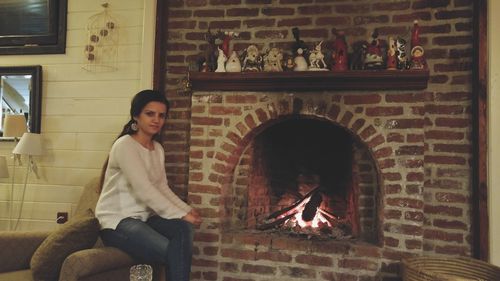 Young woman sitting on wall at home