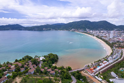 High angle view of city by sea against sky