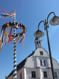 Low angle view of maypole against blue sky