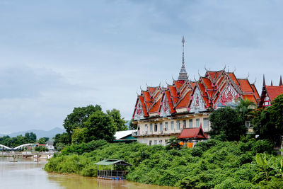 Traditional building by river against sky