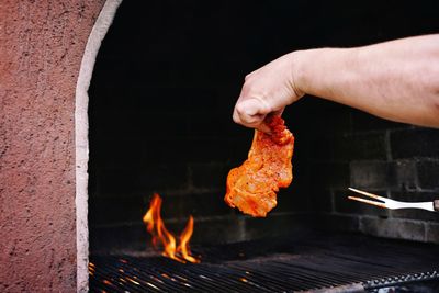 Close-up of person preparing food on barbecue grill