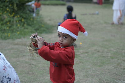 Rear view of boy holding red umbrella