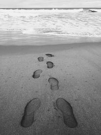 High angle view of footprints on sand at beach