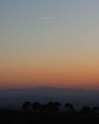 Silhouette landscape against sky during sunset