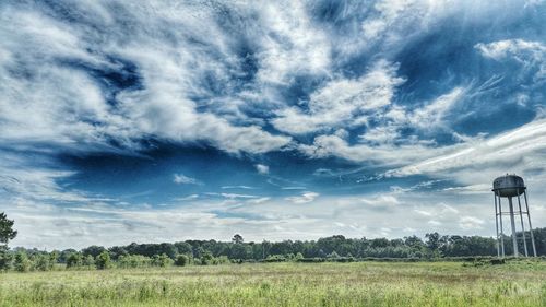 Scenic view of field against cloudy sky