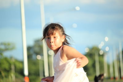 Portrait of girl standing against sky