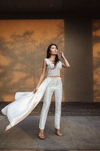 Stunning asian woman in a unique white wedding dress-trouser suit