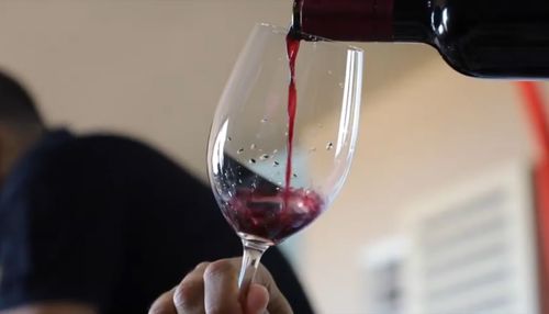 Close-up of hand pouring wine in glass