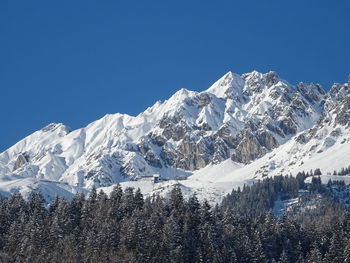 Scenic view of snowcapped mountains against clear blue sky