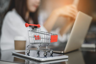 Midsection of woman using mobile phone in store