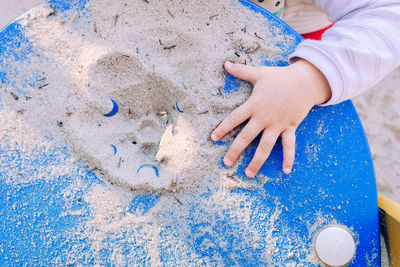 High angle view of girl playing on sand