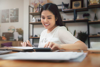 Portrait of young woman using mobile phone at home