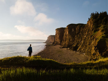 Man watching sunset at cape d'or along the bay of fundy in nova scotia, canada