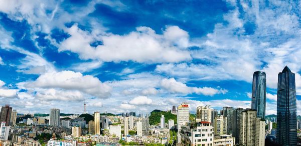 Panoramic view of modern buildings against blue sky