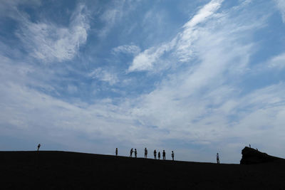 Silhouette of woman against cloudy sky