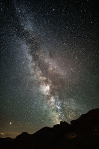 Low angle view of silhouette mountain against sky at night