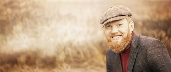 Portrait of smiling young man standing on field