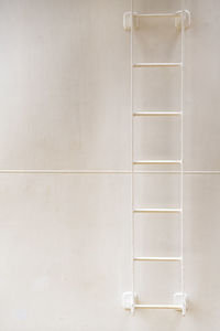 Close-up of ladder against white wall