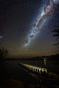 Scenic view of lake against sky at night