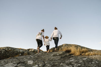 Rear view of women walking with girl