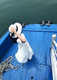 High angle view of woman standing in nautical vessel on sea 