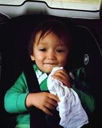 Portrait of smiling cute boy in car