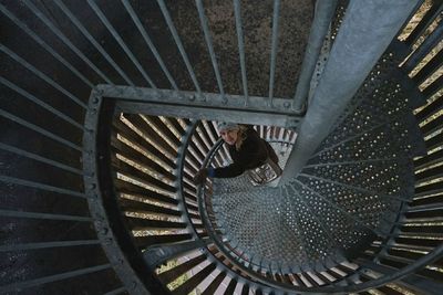 High angle view of woman on metallic spiral staircase