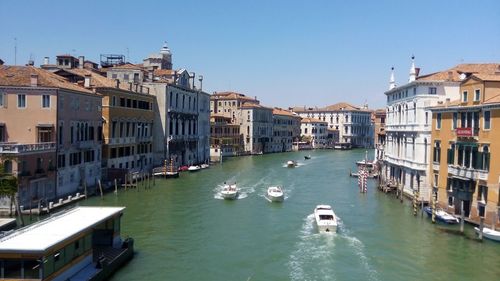 Boats in canal amidst buildings in city