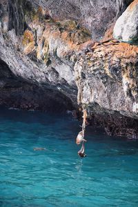 Man surfing on rock in sea