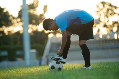 Side view of man playing soccer ball