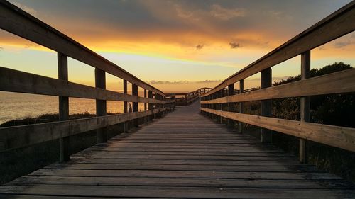 Bridge over footpath against sky during sunset